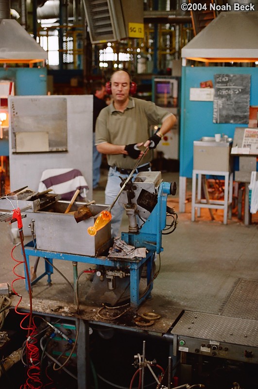 July 6, 2004: This craftsman is preparing to place a molten piece of crystal into a mold to be blown into shape.