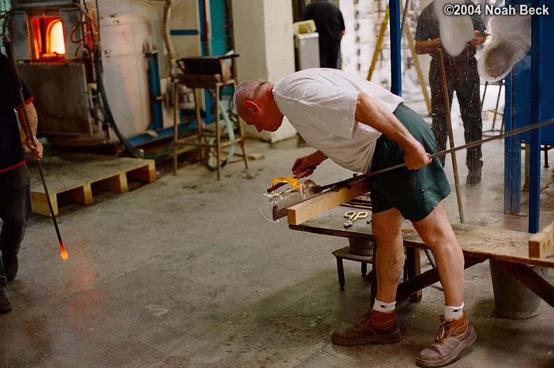July 6, 2004: The craftsman pushes the piece for the handle into the correct shape as it cools into place.